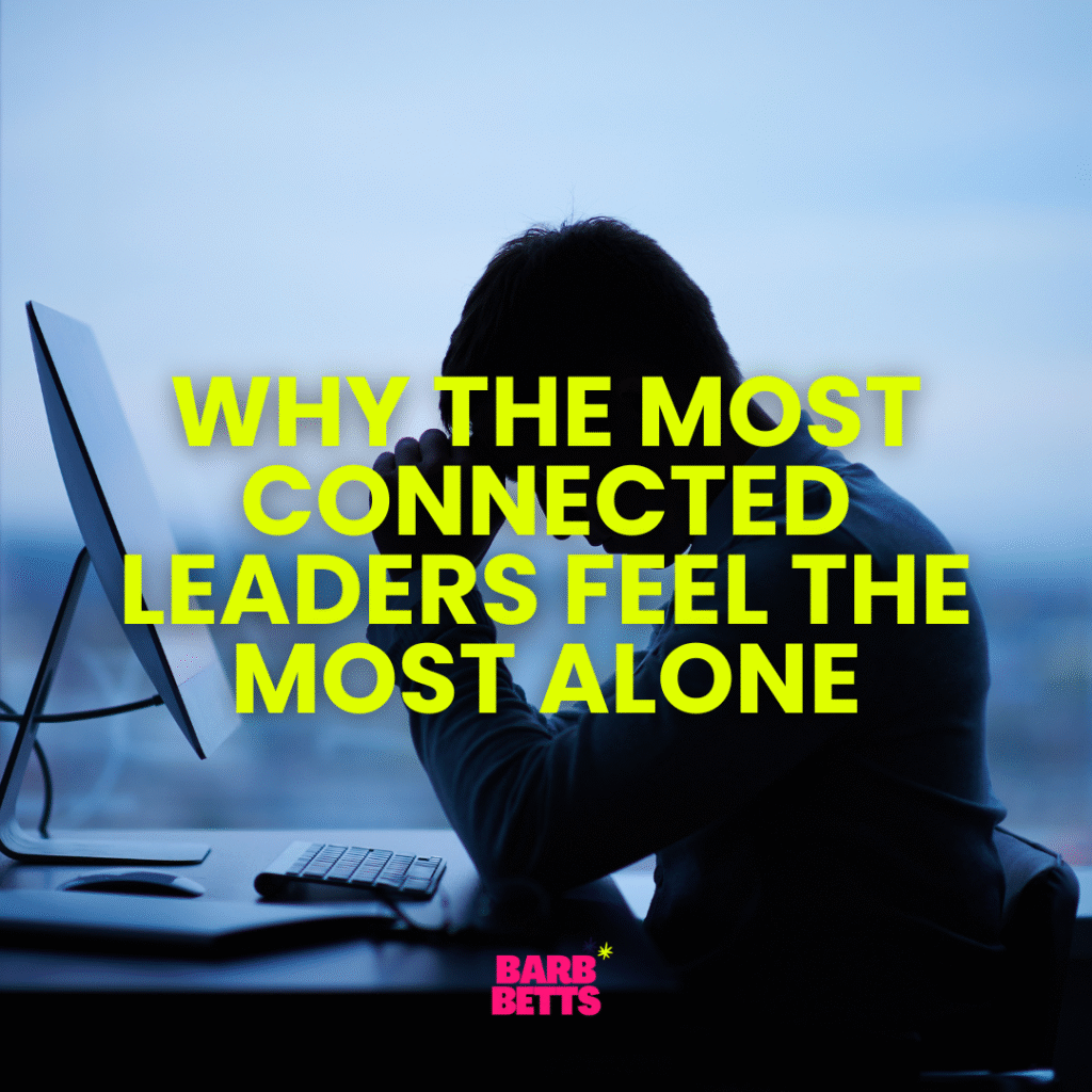 Person sitting at a desk with head in hands, reflecting on loneliness in leadership, with text overlay "Why the Most Connected Leaders Feel the Most Alone" and Barb Betts branding.