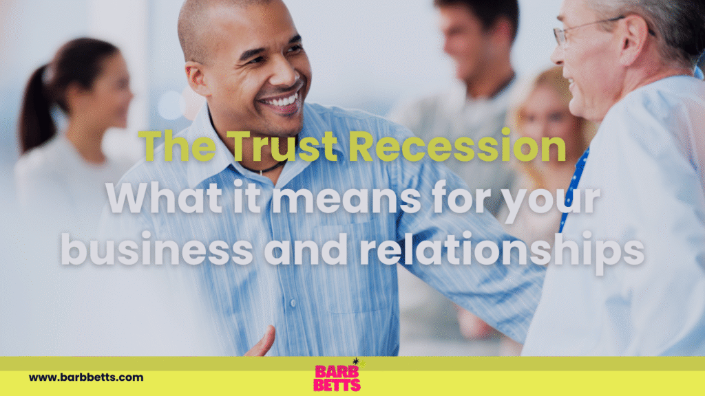 Smiling man engaging in handshake with another professional, overlay text reading "The Trust Recession - What it means for your business and relationships," emphasizing themes of trust and human connection in leadership.